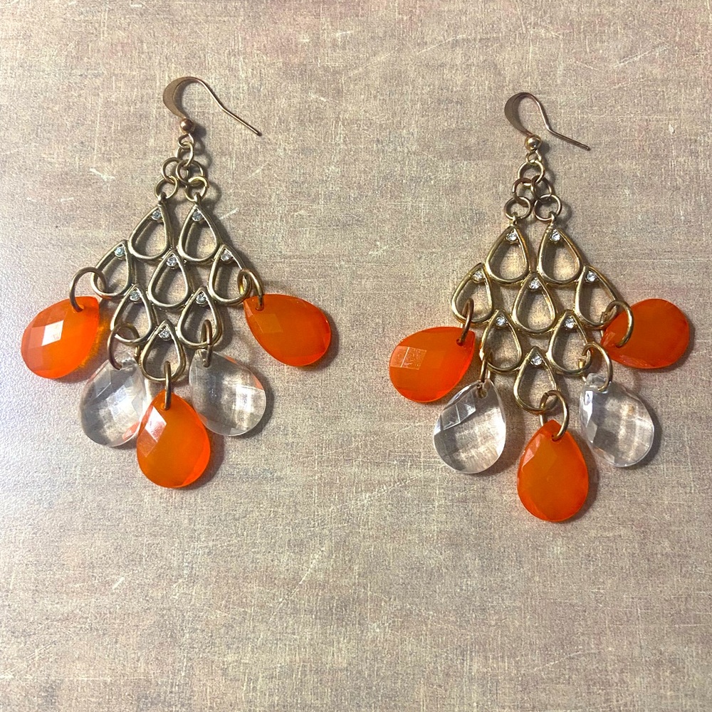 Pierced earrings with orange and clear lucite oval hanging discs